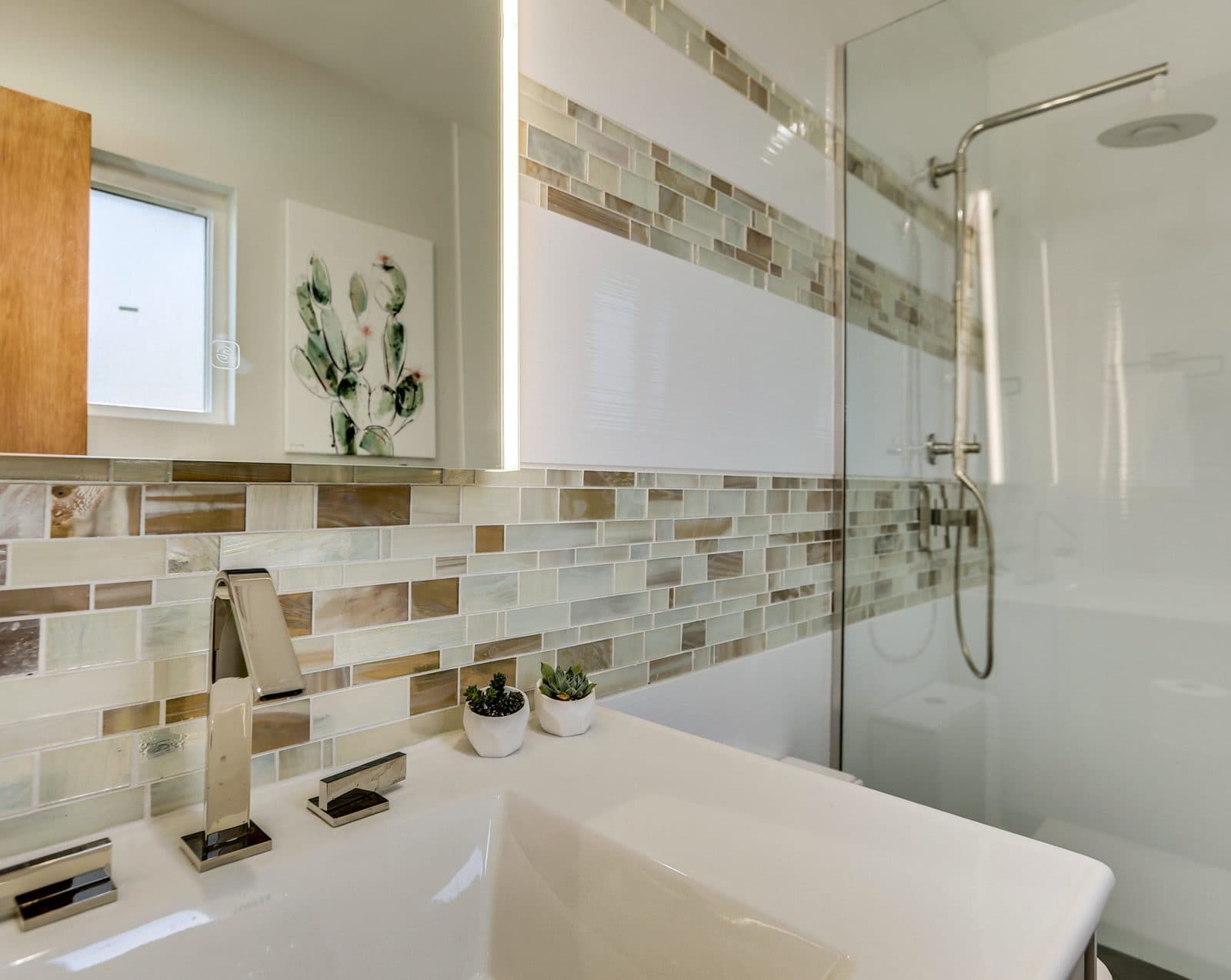 MJ Remodel job photo of a modern bathroom remodel: floating vanity beside a tub with a frameless glass panel and mosaic accent band