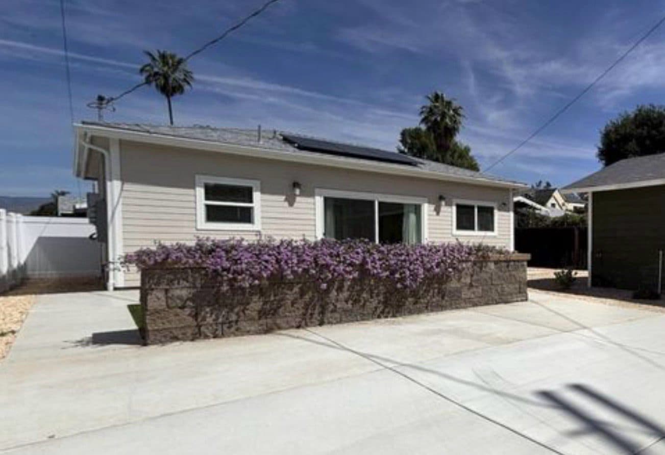 MJ Remodel job photo from an ADU completed in Redlands, CA: rear patio with a sliding door, solar panels, and purple flowers
