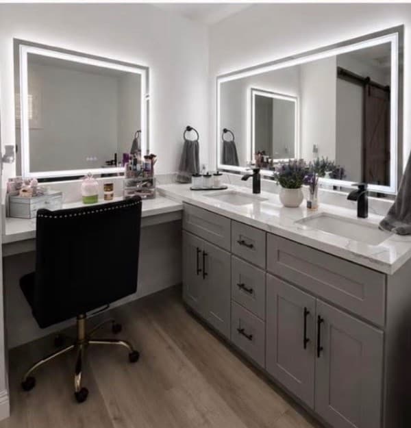 Bathroom vanity with a makeup desk and lit mirrors