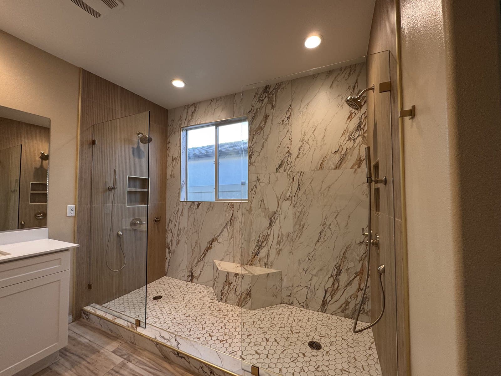 Walk-in shower from the side, glass panel and marble bench